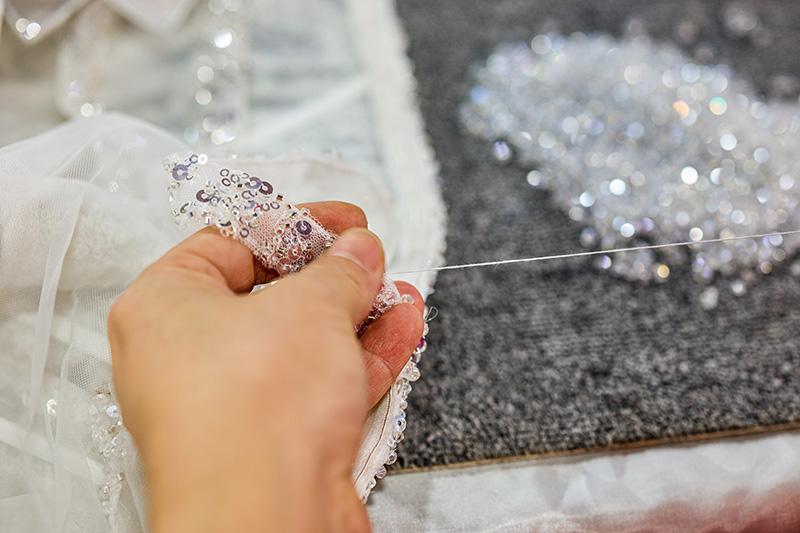 Gorset gaun couture dengan bantalan jarum sedang dihias manik-manik